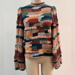 Ulla Johnson crochet sweater with covered buttons and blouson sleeves.